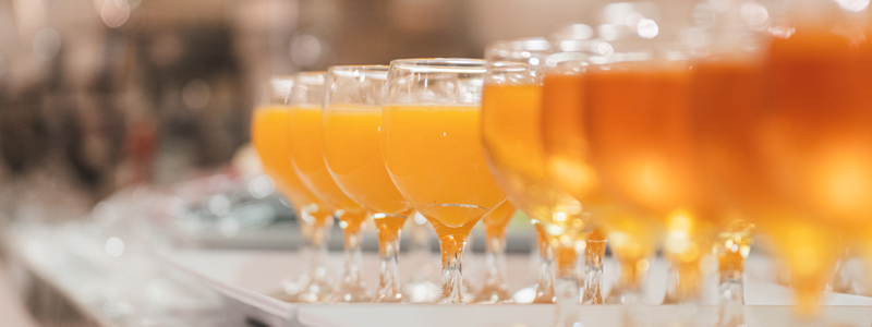 close up of orange juice and iced tea glasses